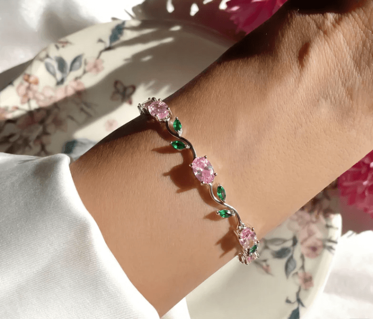 Silver-plated tulip bracelet features pink oval stones and green leaf accents